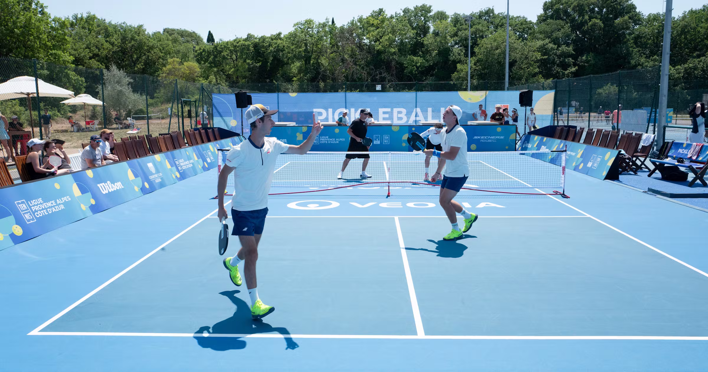 Coach pickleball en session avec des joueurs sur le terrain